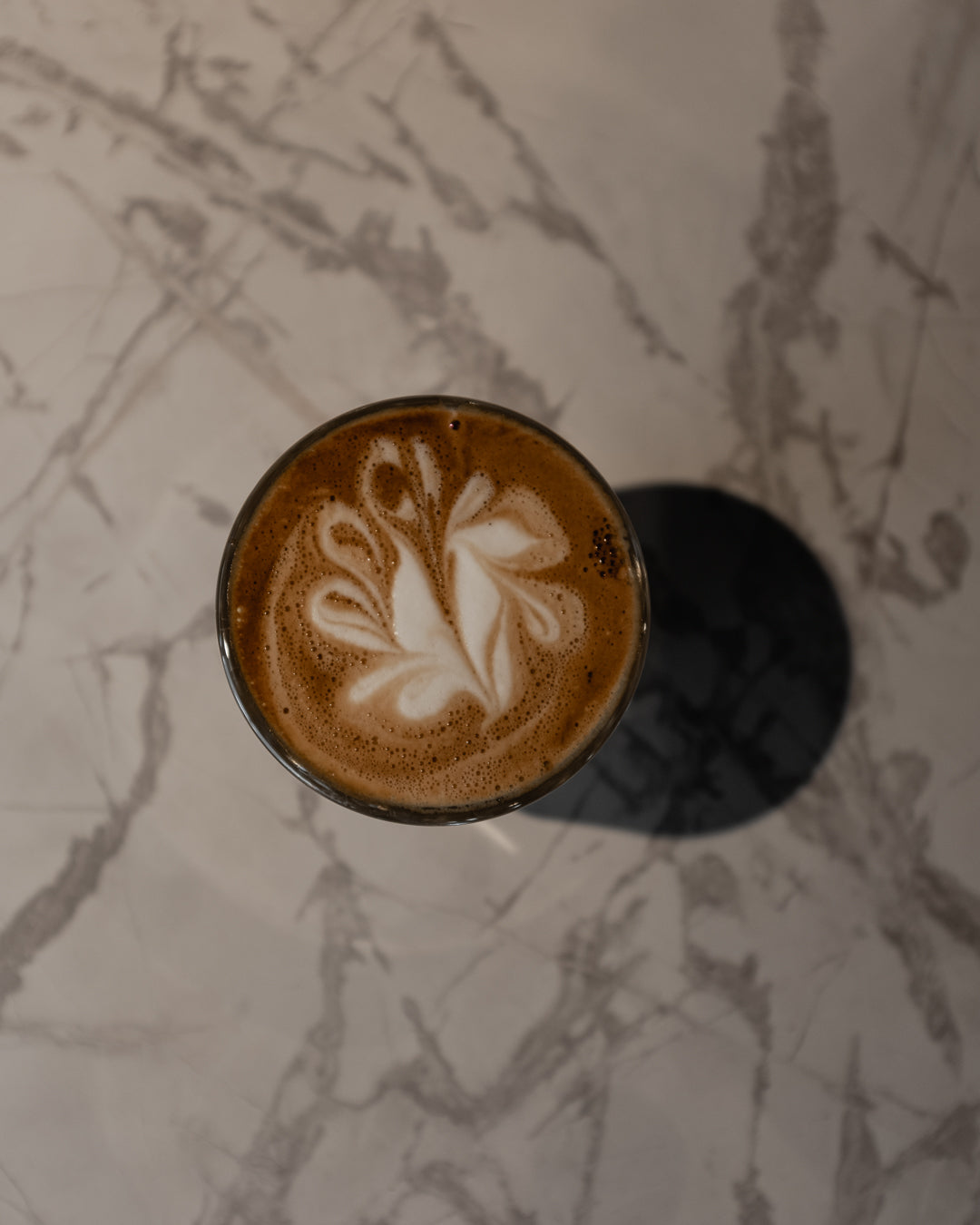 Latte art in a glass on marble at The Roasted Record cafe